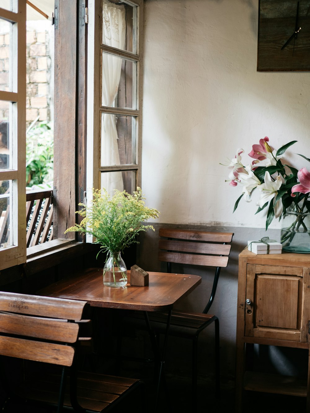 yellow flower on vase at the table beside window