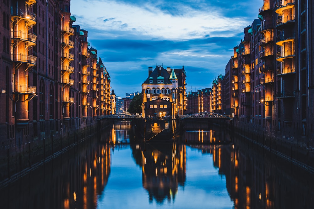 body of water between high buildings at golden hour