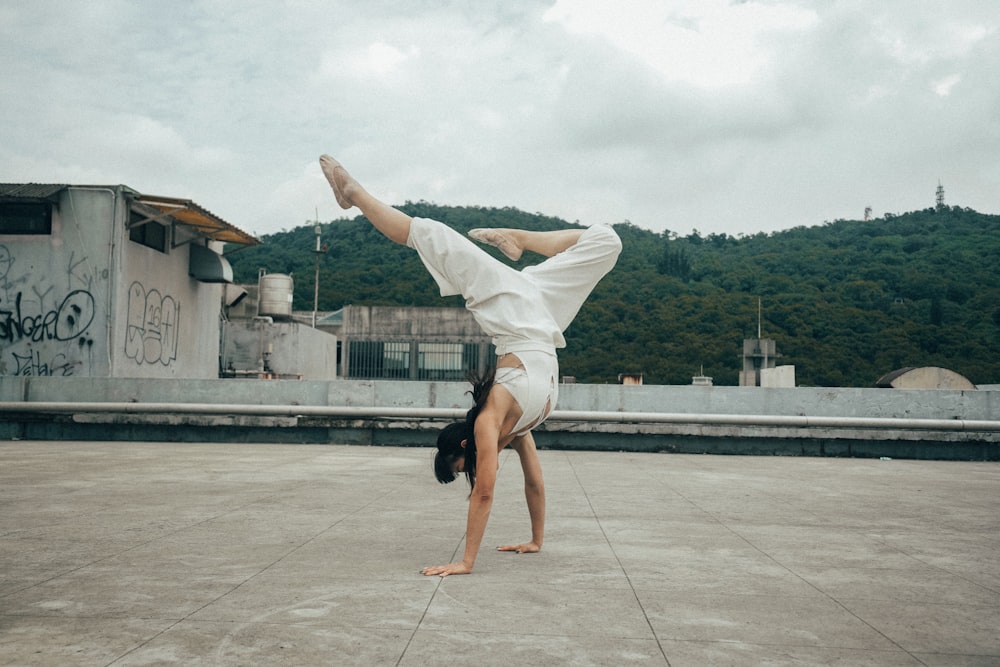 a person doing a handstand on a concrete surface