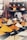A variety of colorful spices are displayed in conical piles on a market stall, each labeled with small black signs. In the background, large jars filled with different substances are neatly arranged on shelves.
