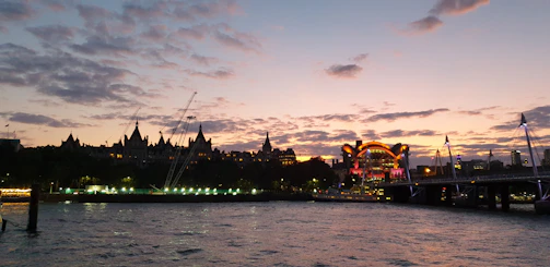 A panoramic view of a sprawling urban bridge under construction at sunset with golden light reflecting off steel beams.