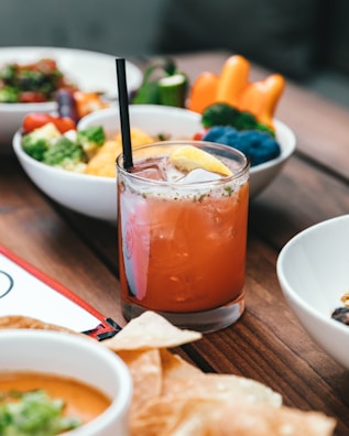 A refreshing glass of fresh lemonade with condensation beads, sitting beside a garden fresh salad.