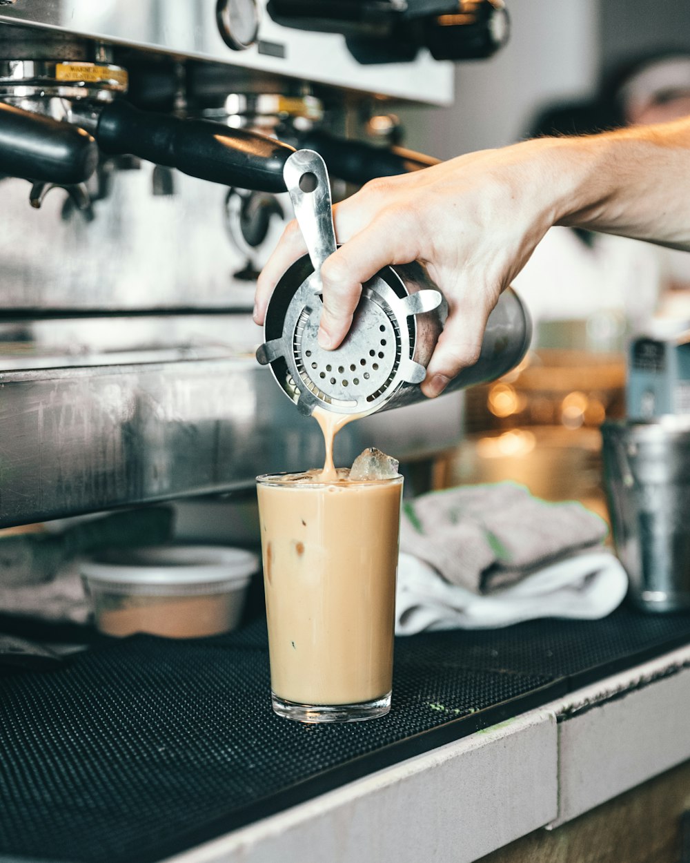 person pouring coffee in drinking glass