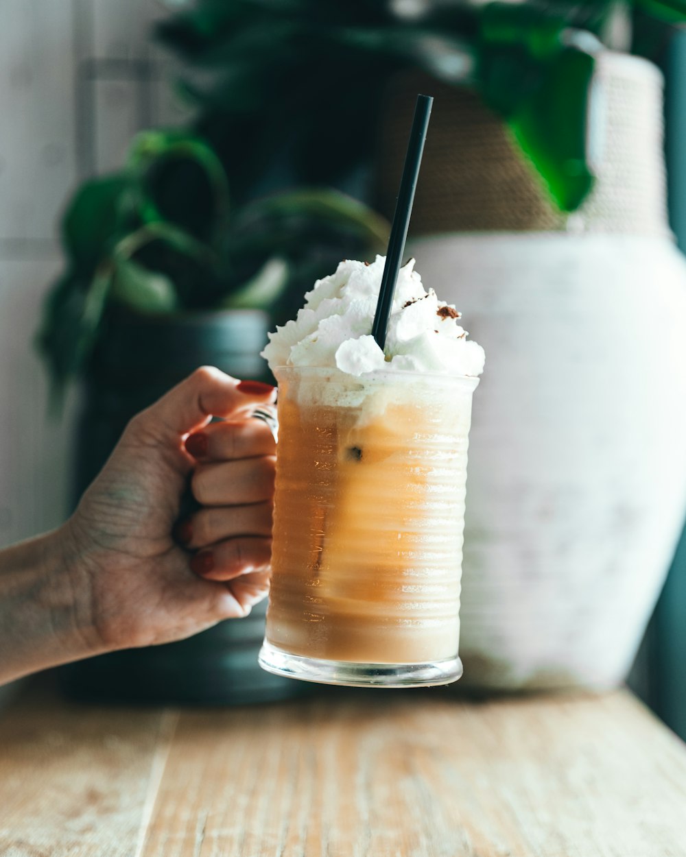 person holding clear glass of shake