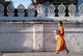 man walking beside wall