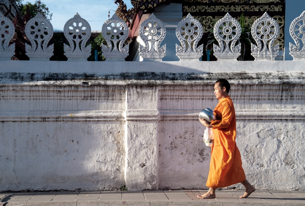 man walking beside wall