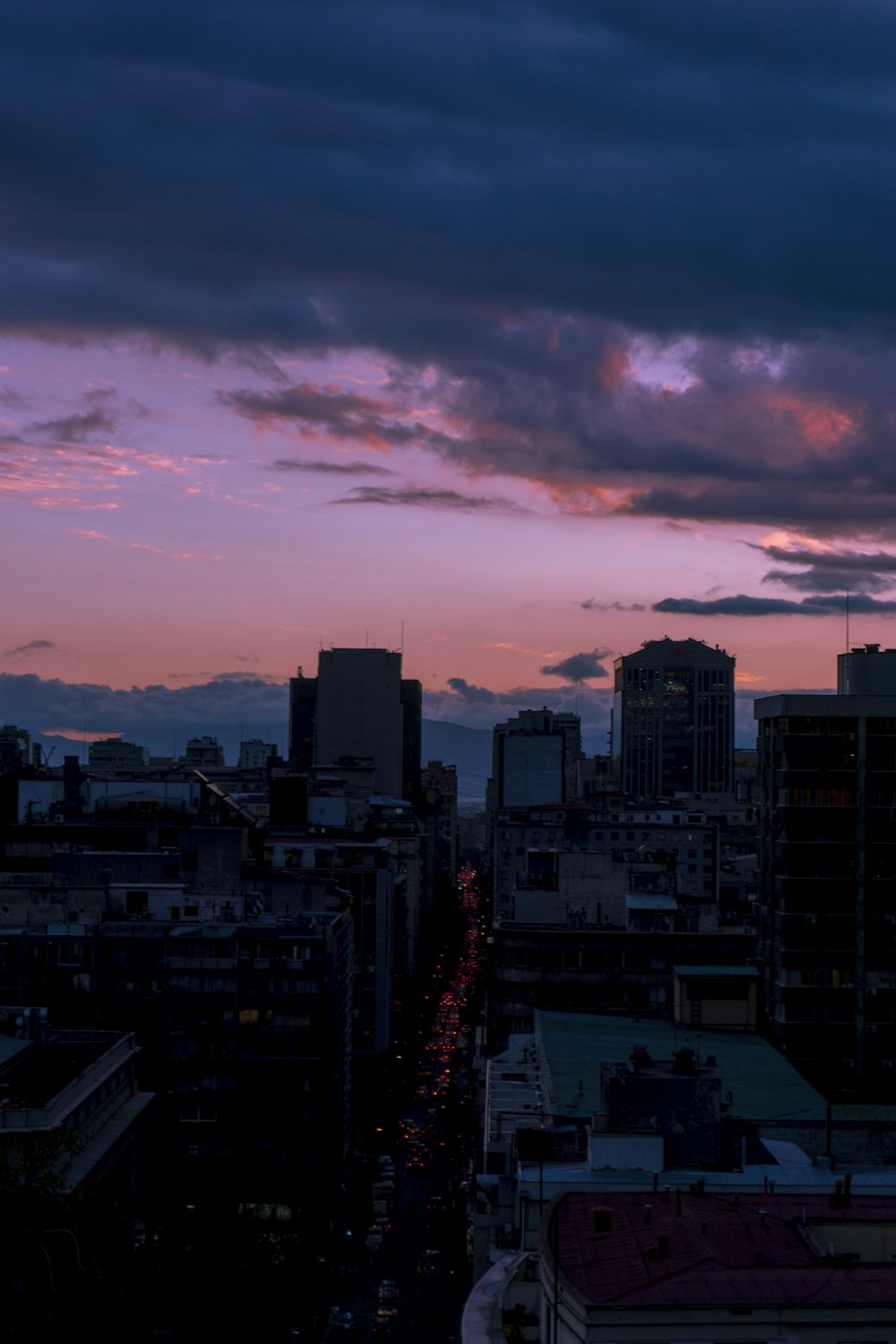 grey clouds looming above the city during sunset