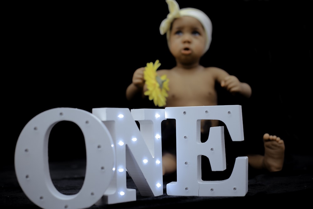 one freestanding letters with vanity lights in front of sitting baby doll