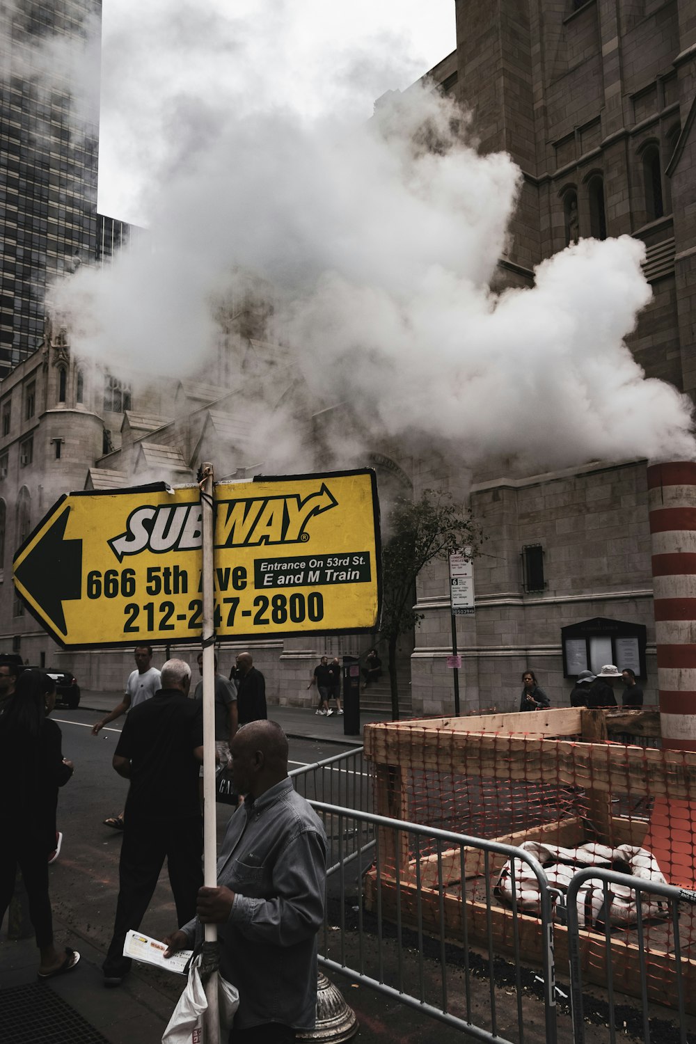 man holding Subway signage