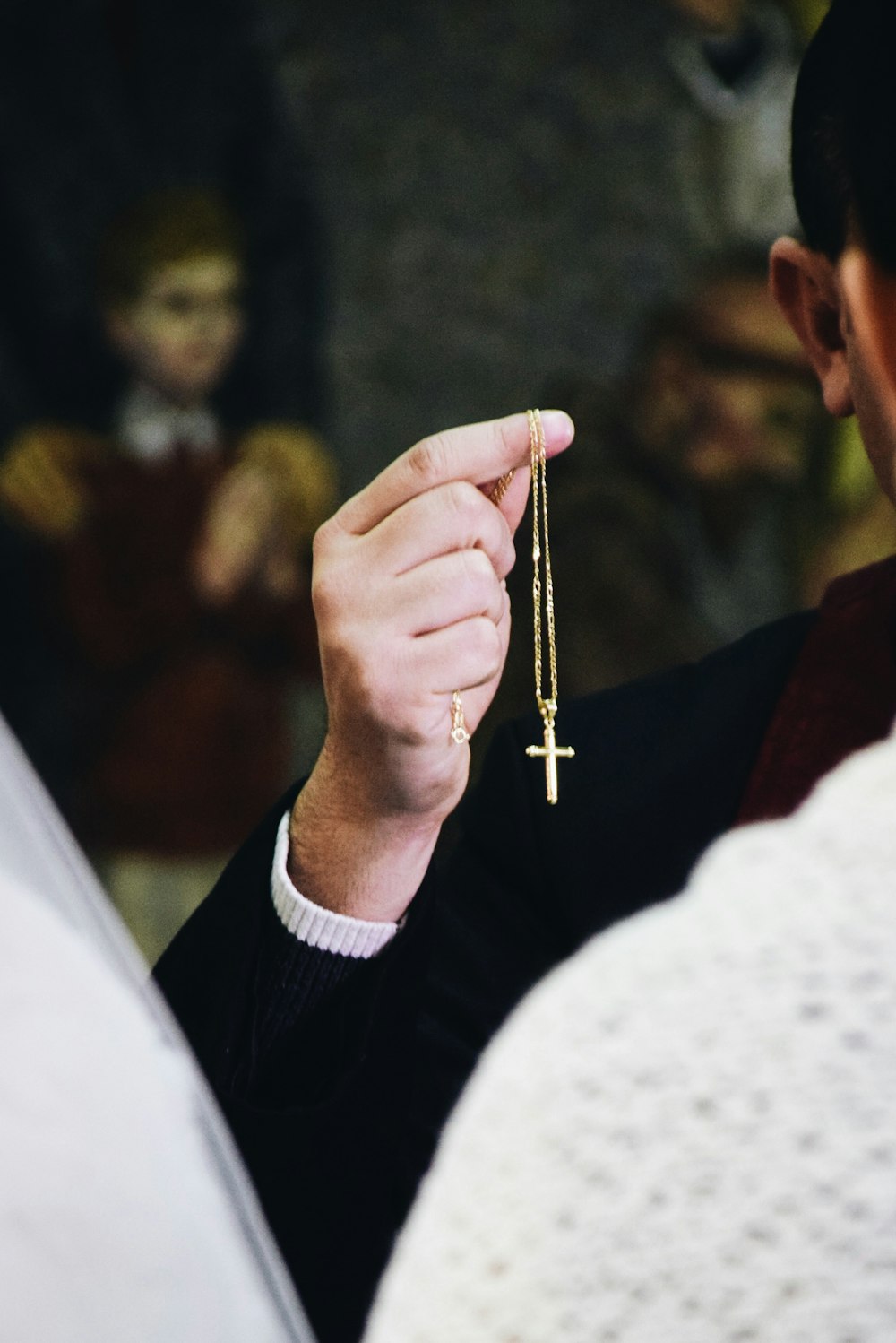 man holding cross pendant