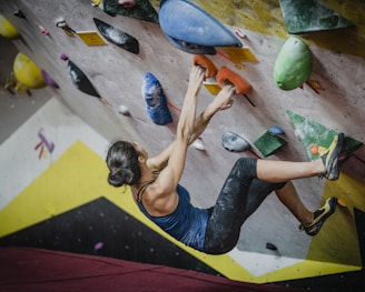 woman rock climbing inside building