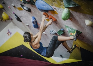 woman rock climbing inside building