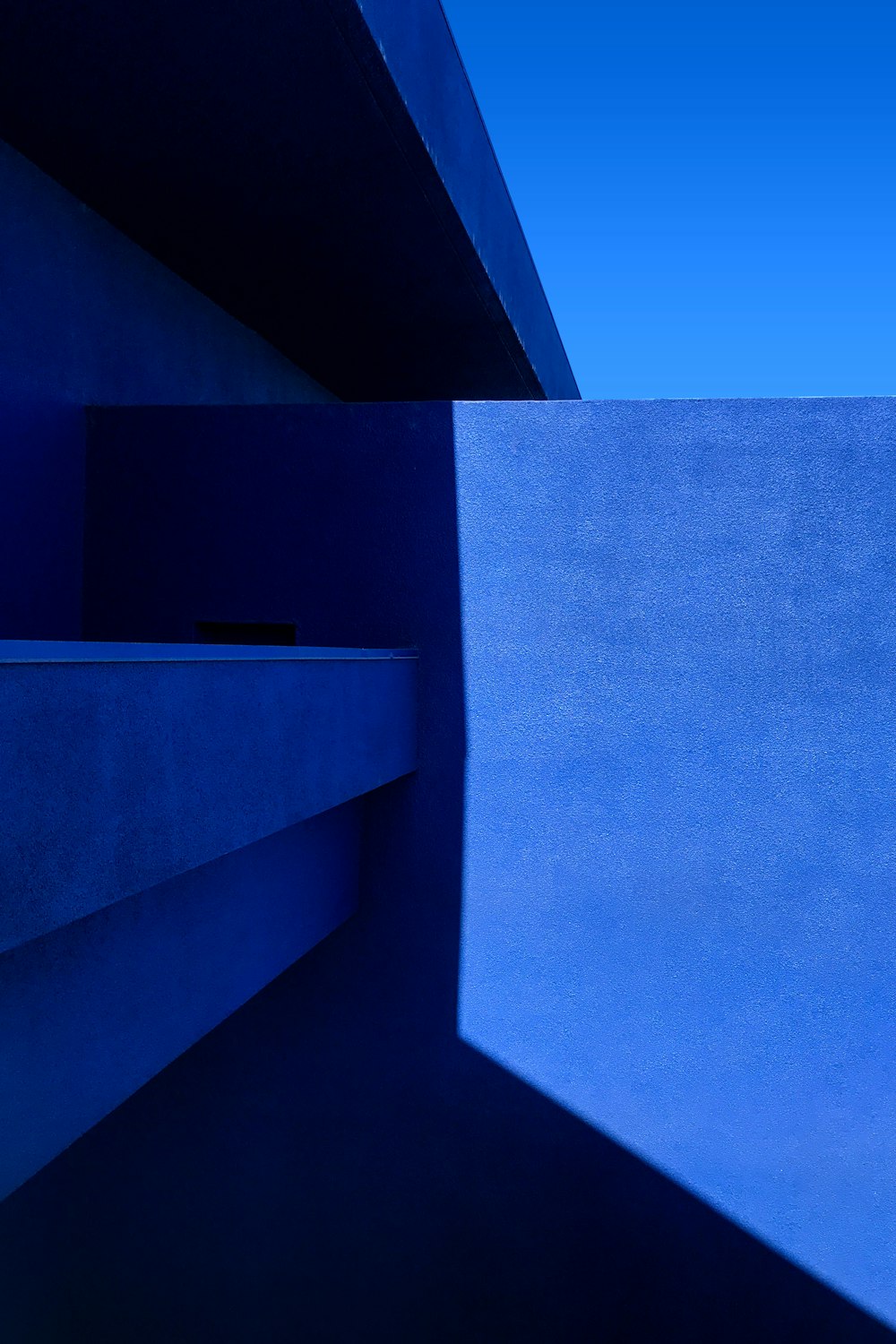 a blue building with a blue sky in the background