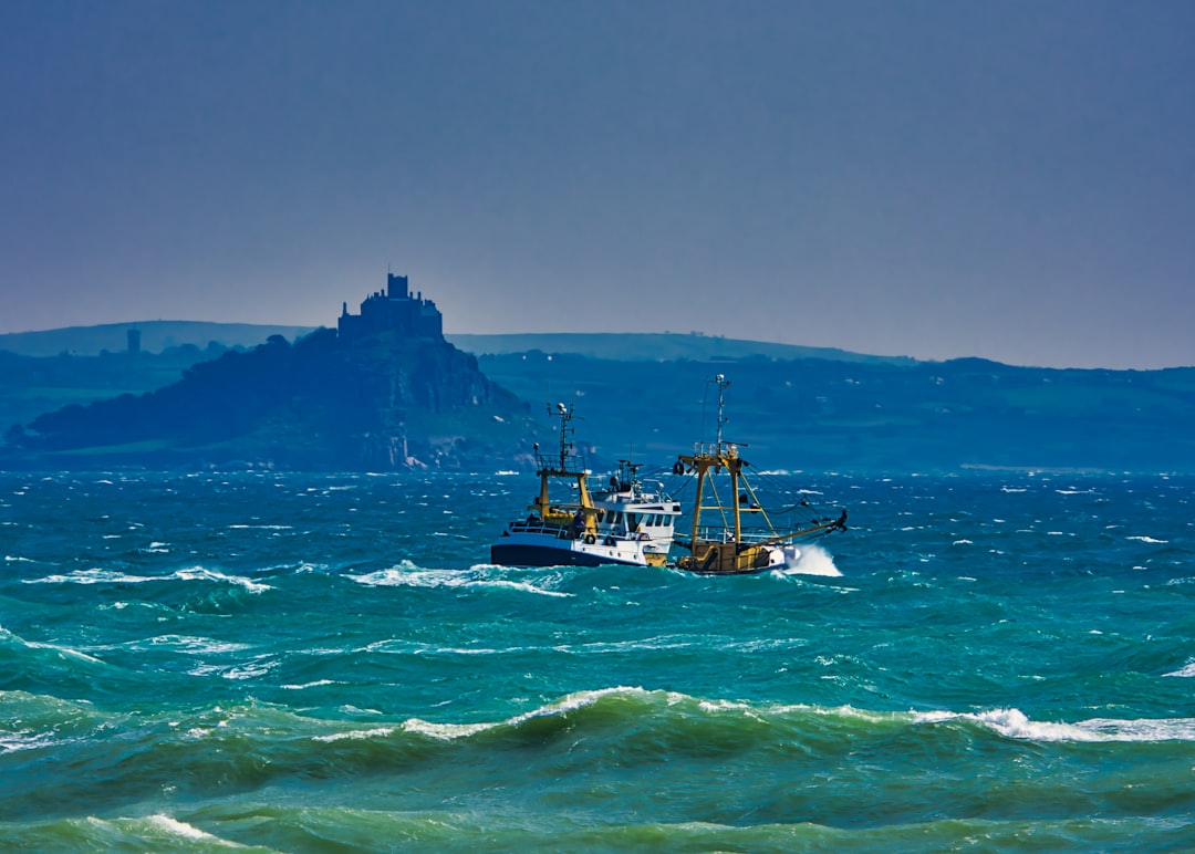 Fishing trawler sailing past St Michael's Mount in Cornwall