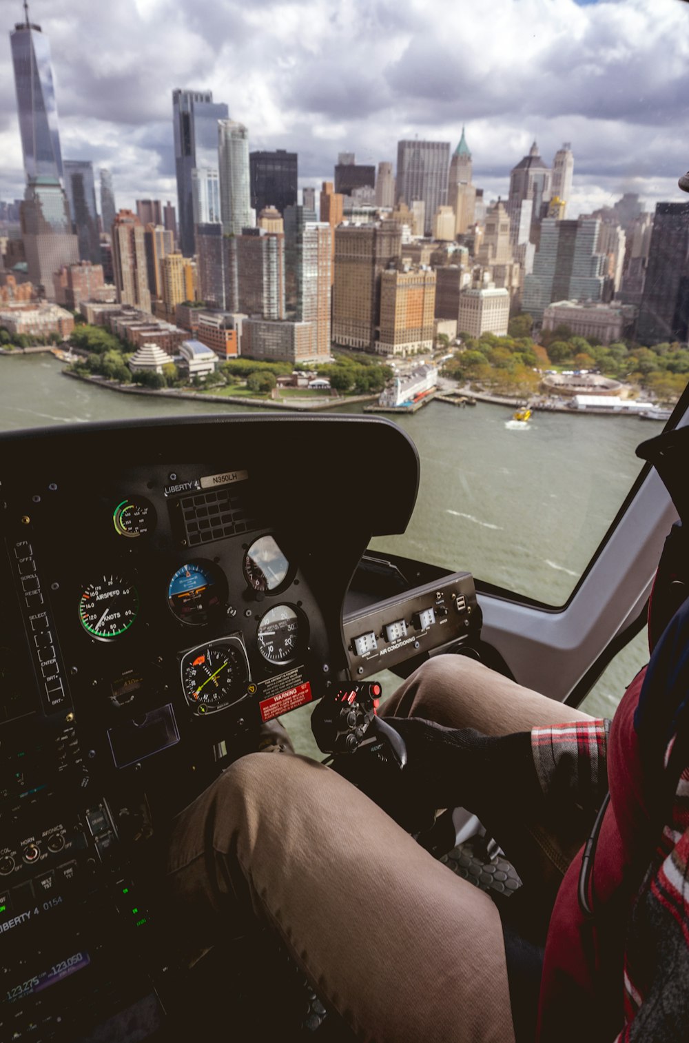 man riding helicopter near buildings