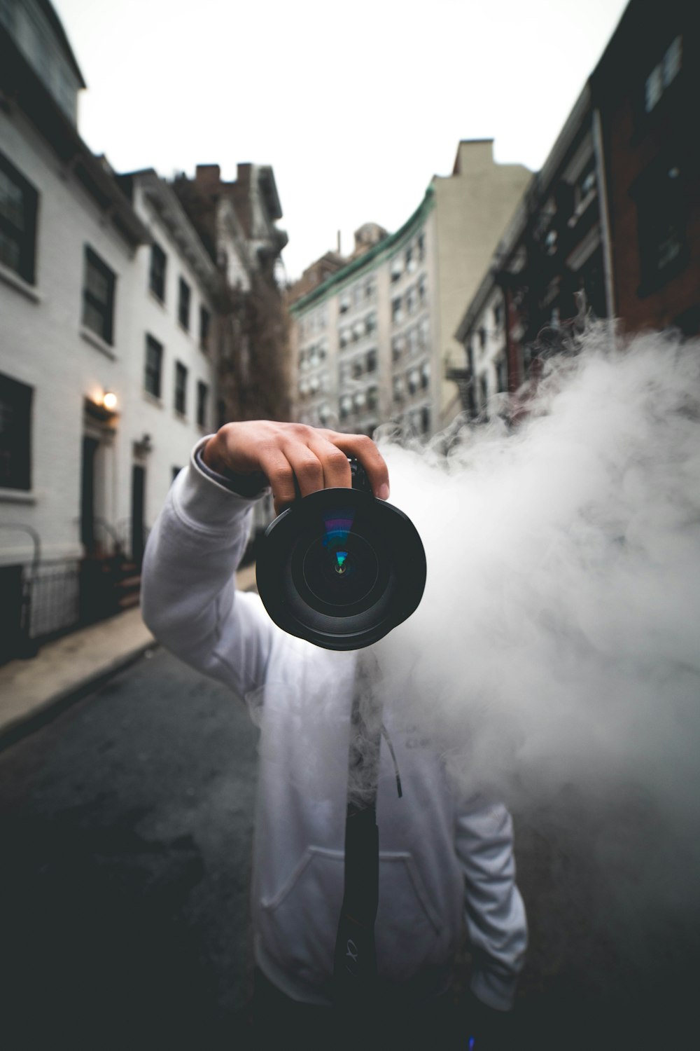 person holding a camera with smoke