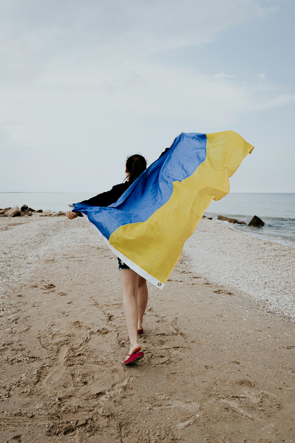 walking person holding blue and brown striped banner