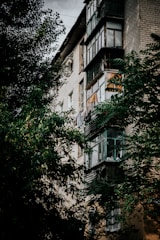 Exterior view of a multi-family brick building with balconies and greenery.