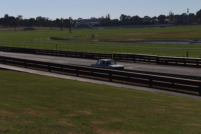 A classic 1955 Chrysler road race car on a racetrack.