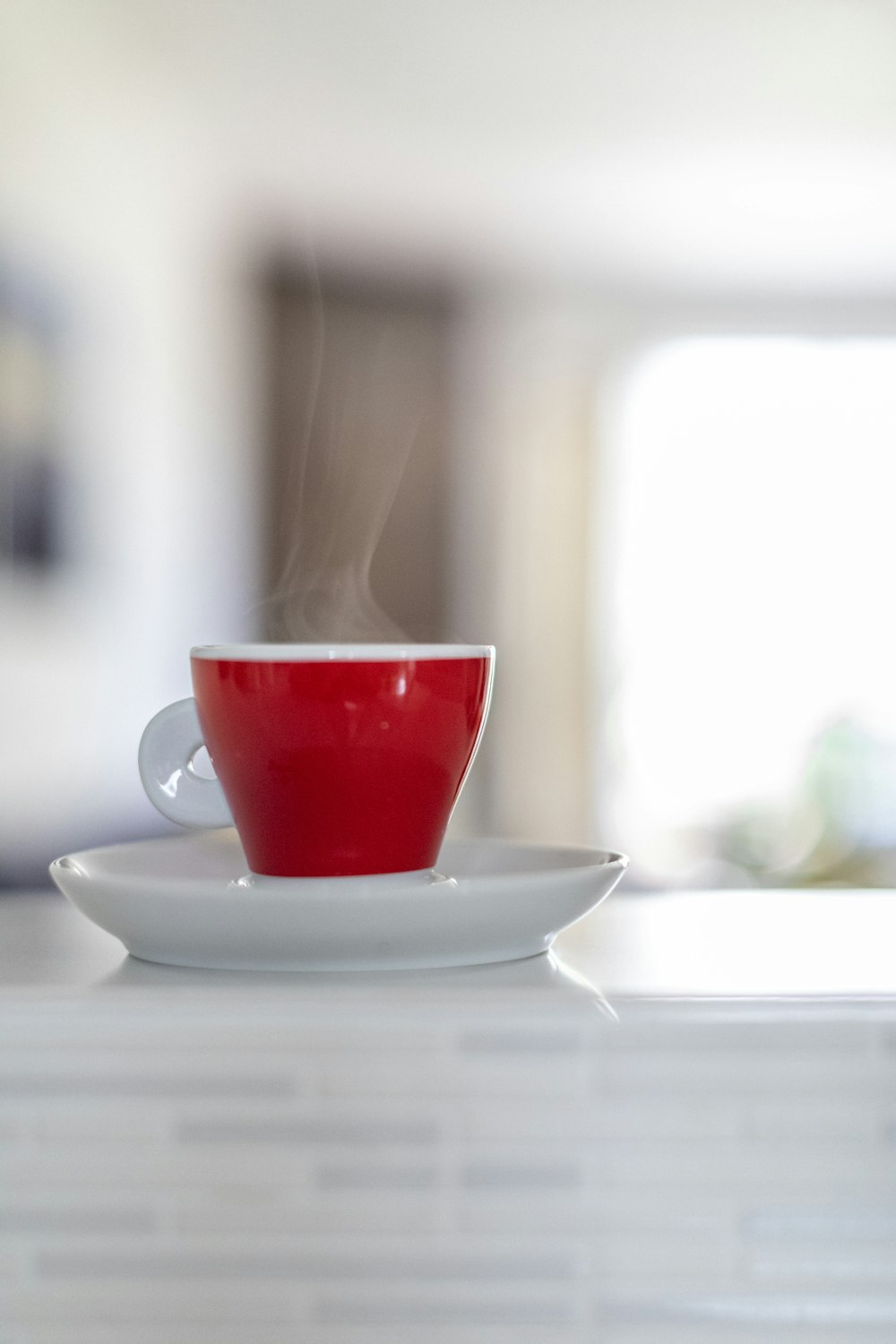 red ceramic mug on top of white saucer