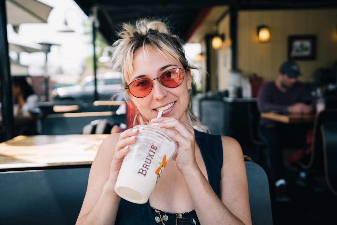 smiling woman supping on disposable cup