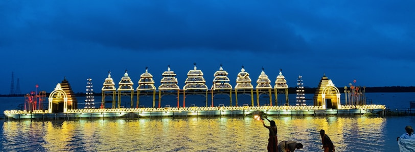 Drones illuminating the sky with intricate designs, reflecting on water below
