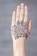 A hand with intricate henna art on the top, featuring floral motifs and swirling patterns. The design is symmetrical and detailed, focusing on two main flower shapes surrounded by leaves and dots.