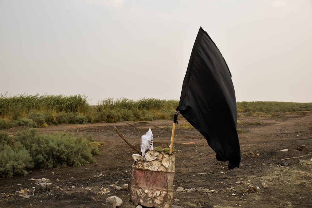 black flag placed on red and white drum container