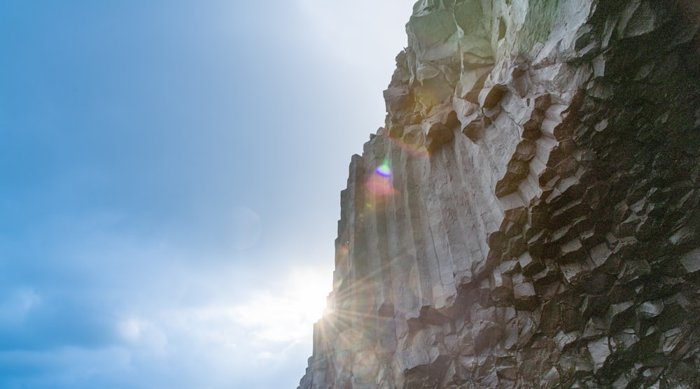 the sun shines brightly on a rock face