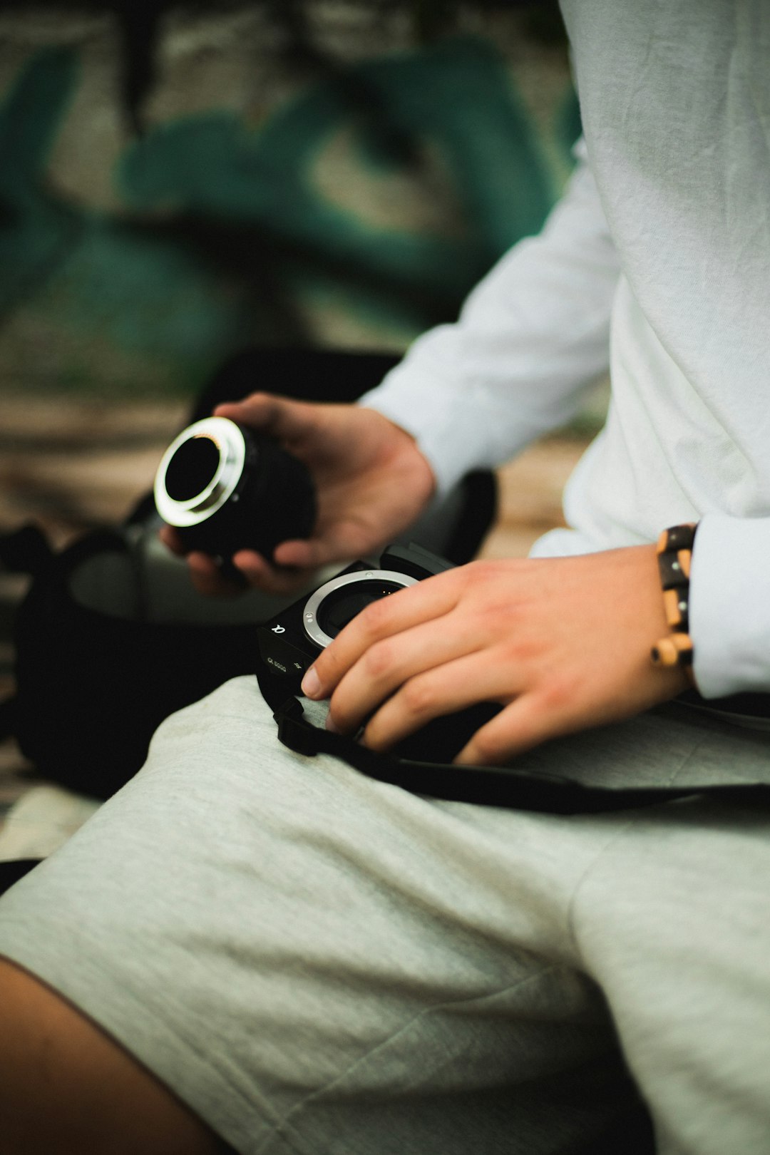 closeup photo of man sitting and holding camera zoom lens