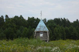 A traditional countryside chapel surrounded by blooming wildflowers.