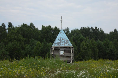 A traditional countryside chapel surrounded by blooming wildflowers.