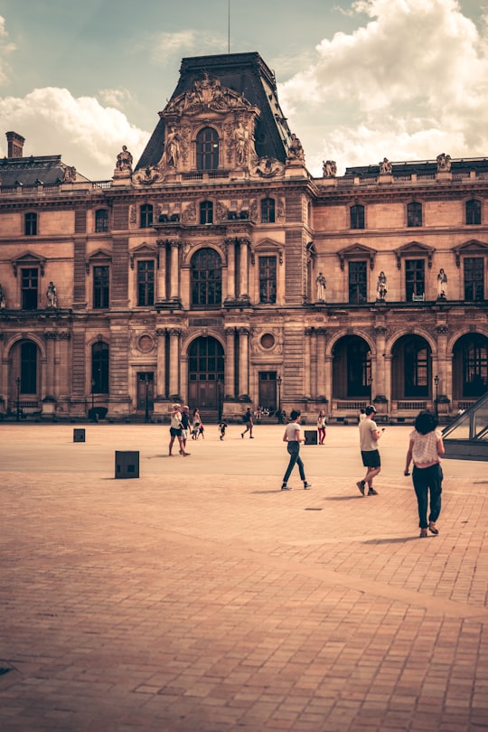 people walking near concrete building during daytime in Louvre France