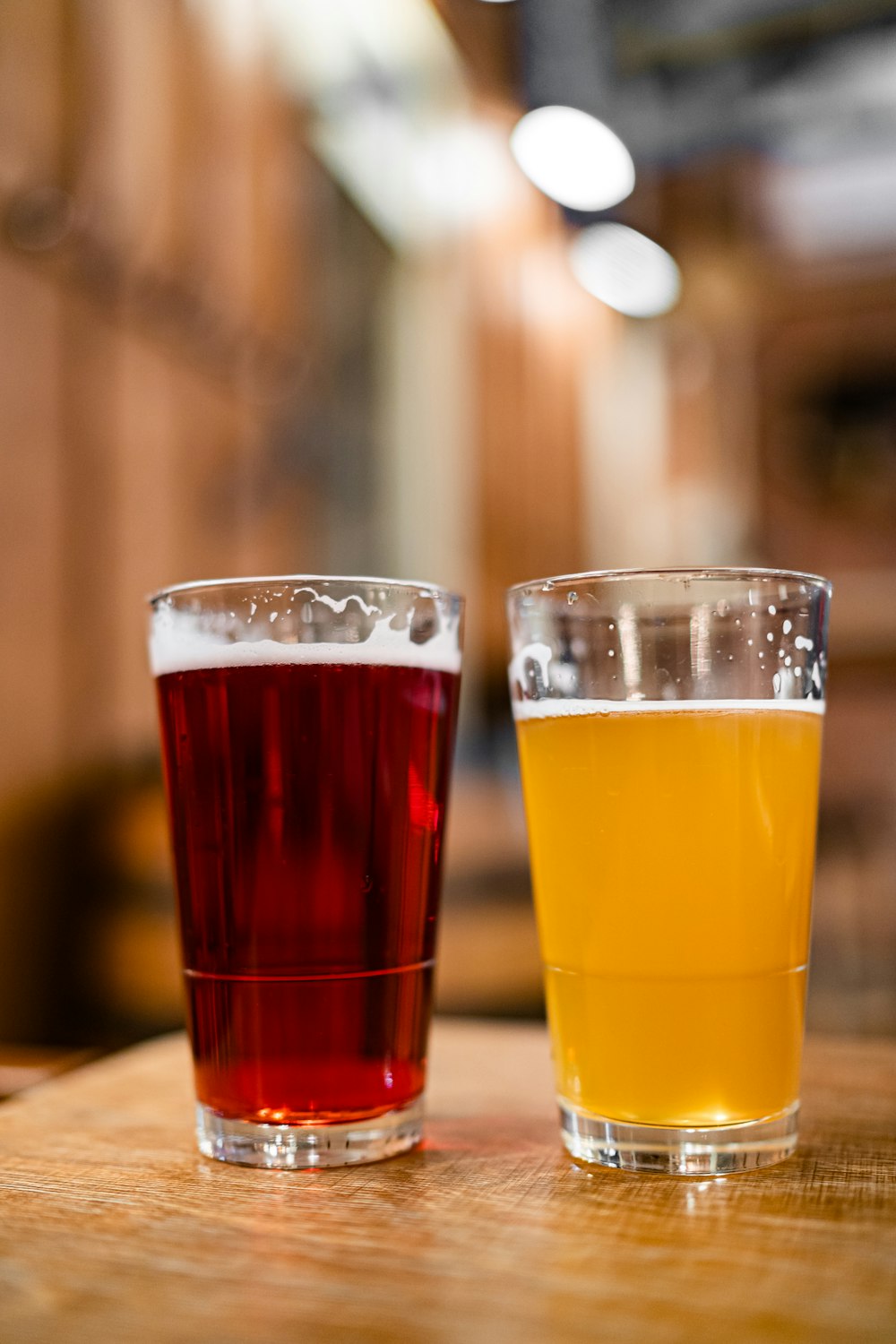 two clear drinking glasses filled with yellow and red liquid