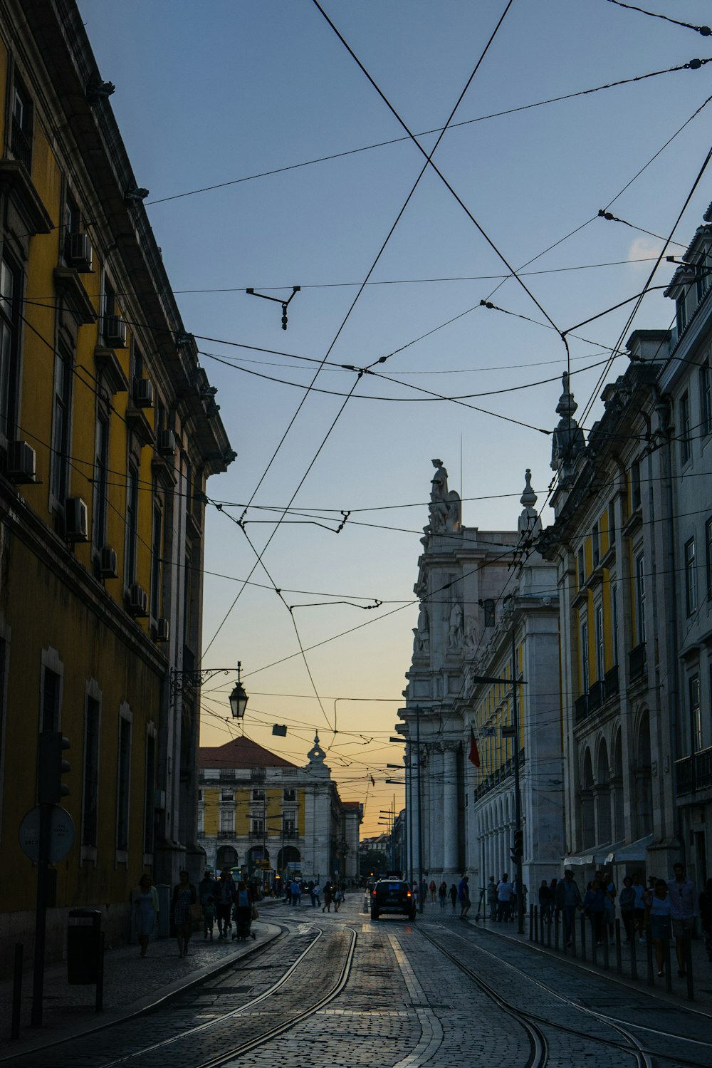 people walking on sidewalks beside buildings and road