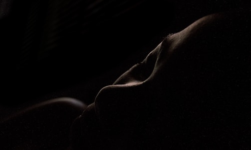 Close-up of a softly lit silhouette highlighting curves and shadows.