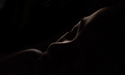 A tasteful close-up of a sensual silhouette with soft lighting.