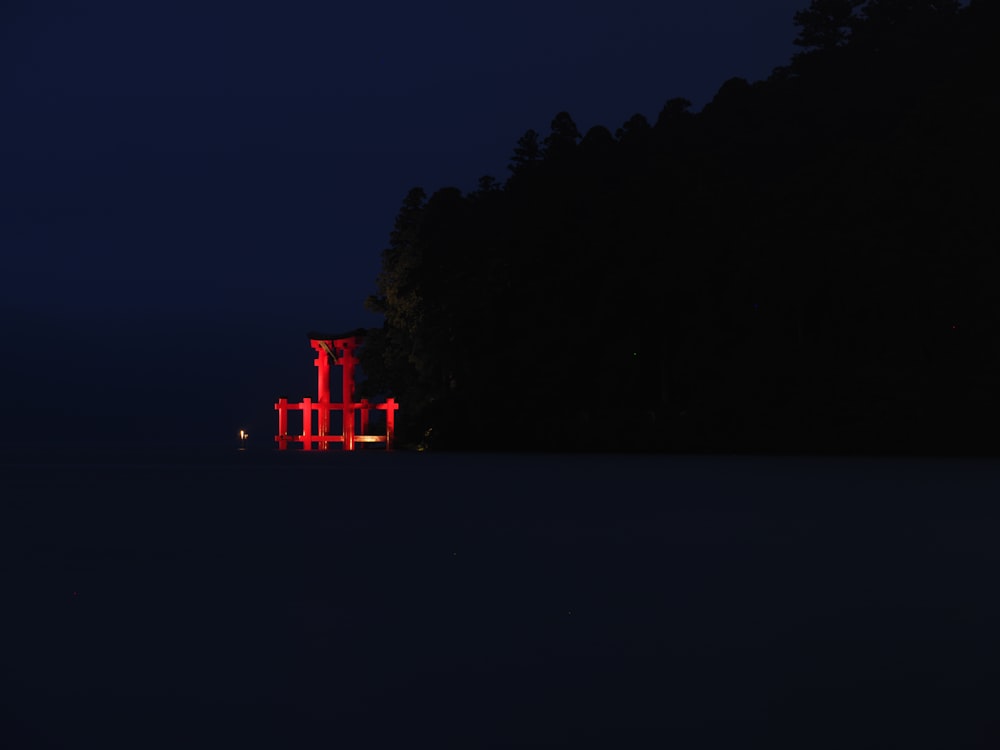 a red structure in the middle of a field at night