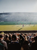 A friendly football match taking place on a green field under a clear sky in Berlin.