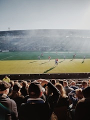Families enjoying a football match on the sidelines.