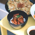 a yellow table topped with bowls of food