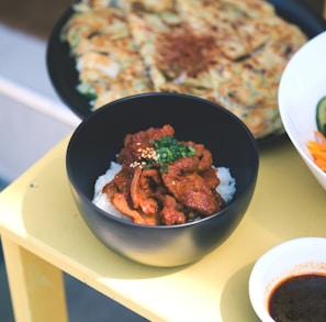 a yellow table topped with bowls of food