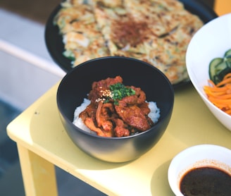 a yellow table topped with bowls of food