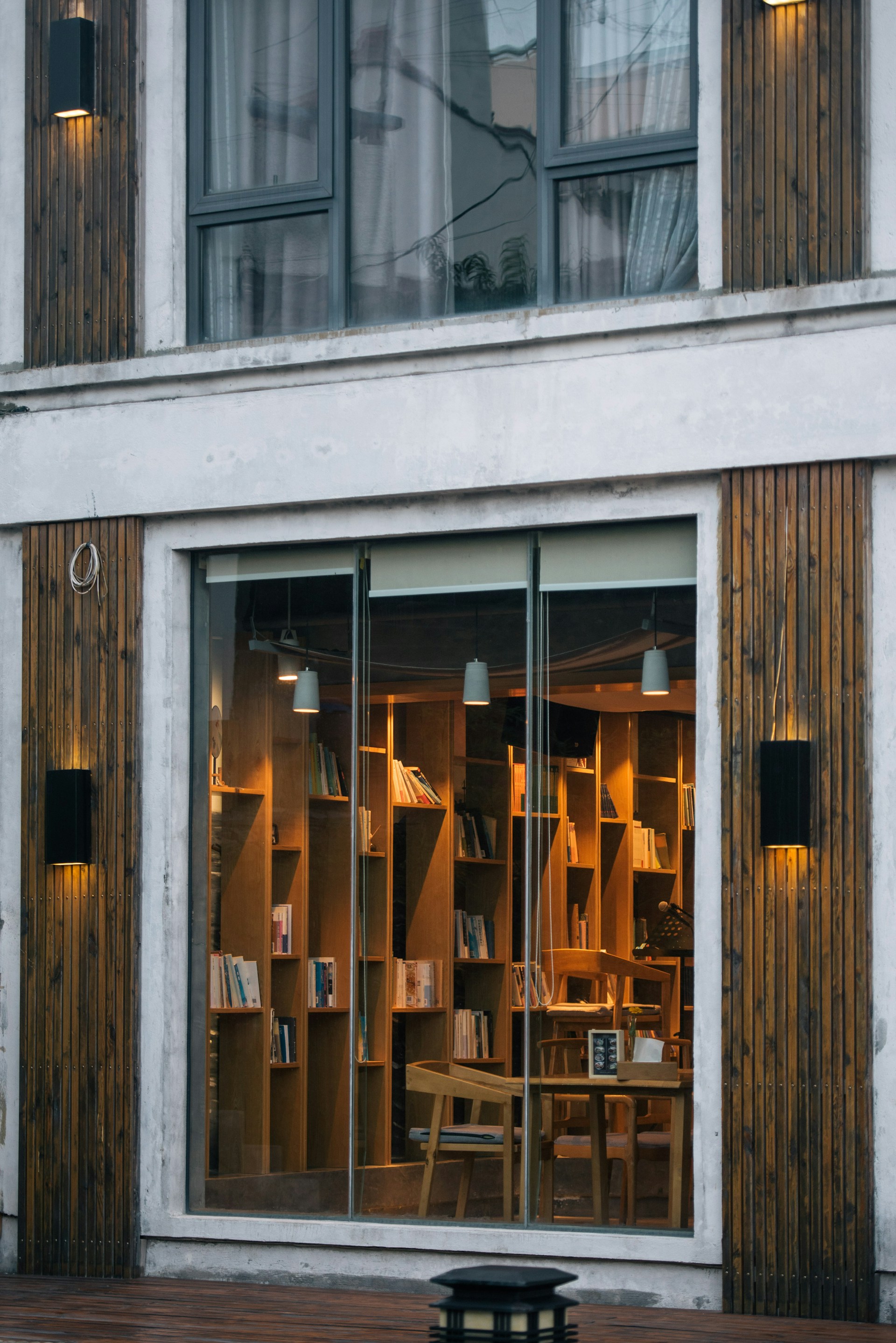 The exterior of Surya Library at dusk, with warm yellow lighting highlighting its refined black and white facade in Kasiram Nagar, Moradabad.