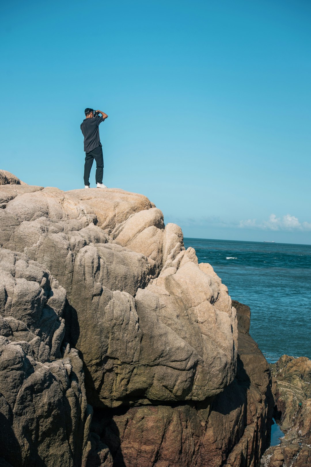 man standing on cliff at daytime