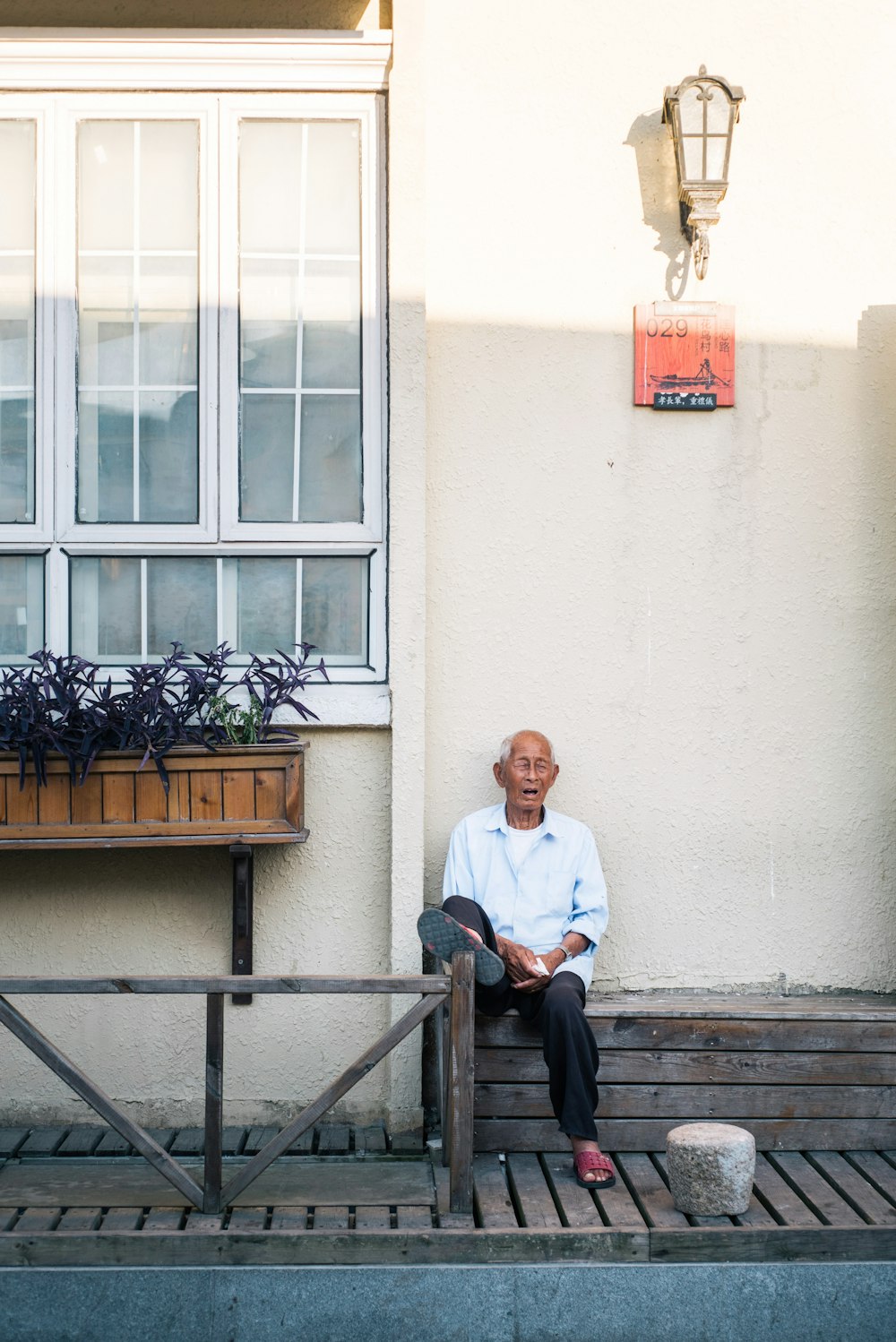 man sitting in front of white painted wall