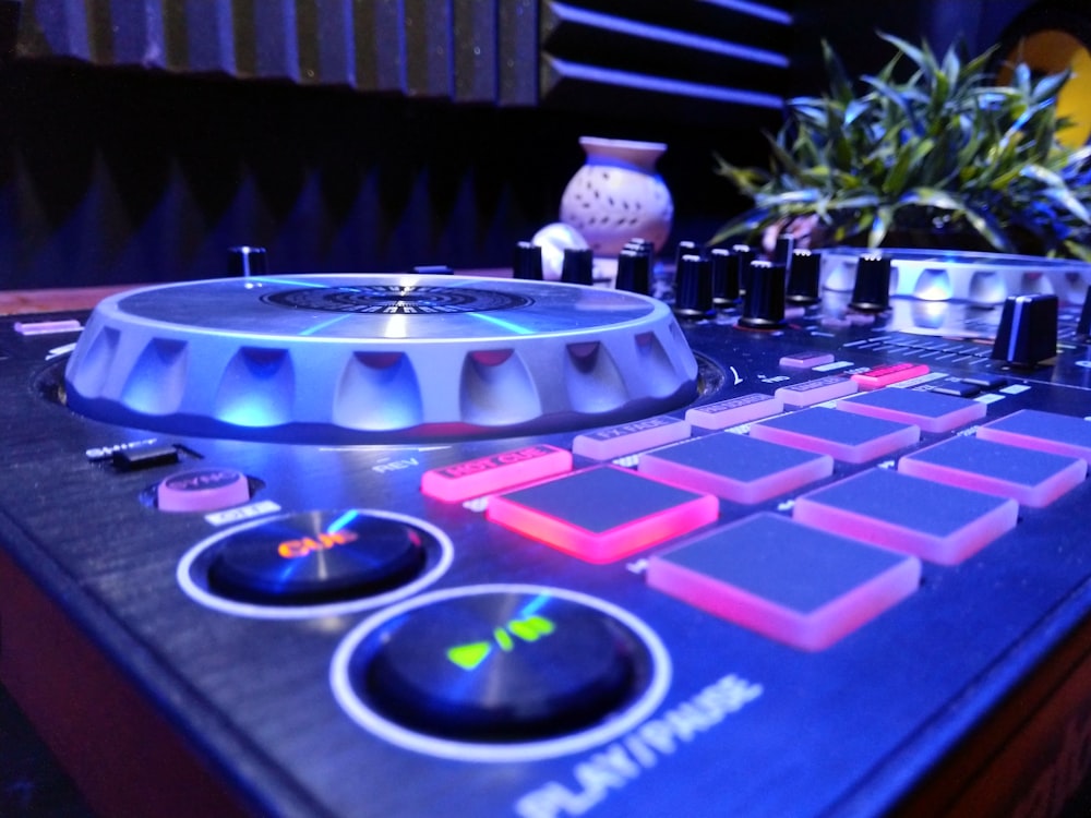 a close up of a dj controller with a plant in the background