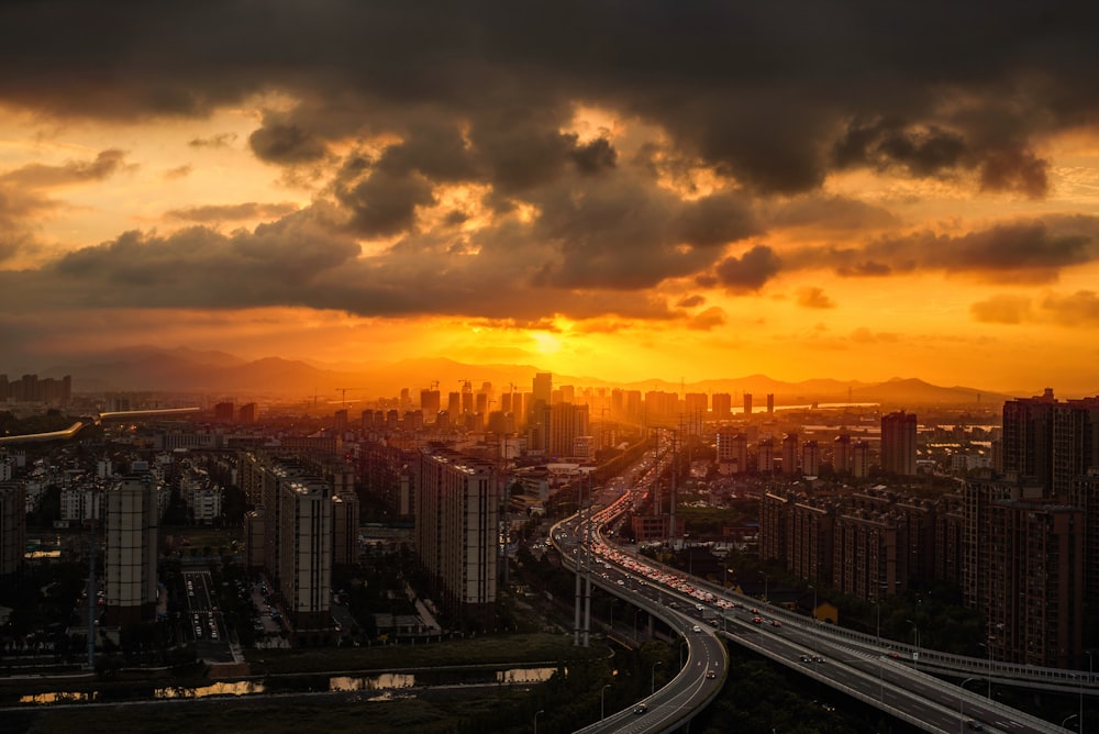 city with high-rise buildings under orange and gray skies