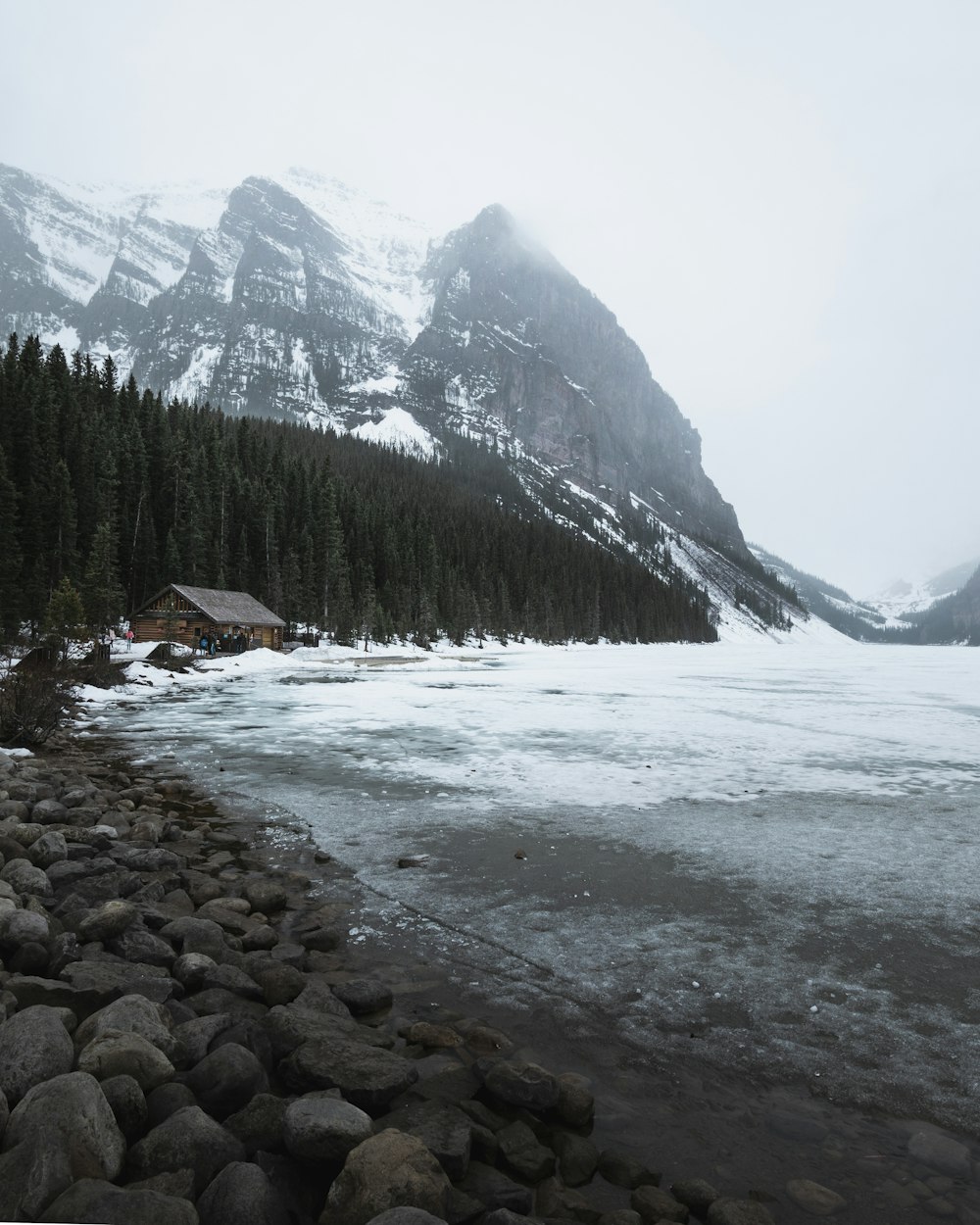 house near field covered with snow viewing mountain