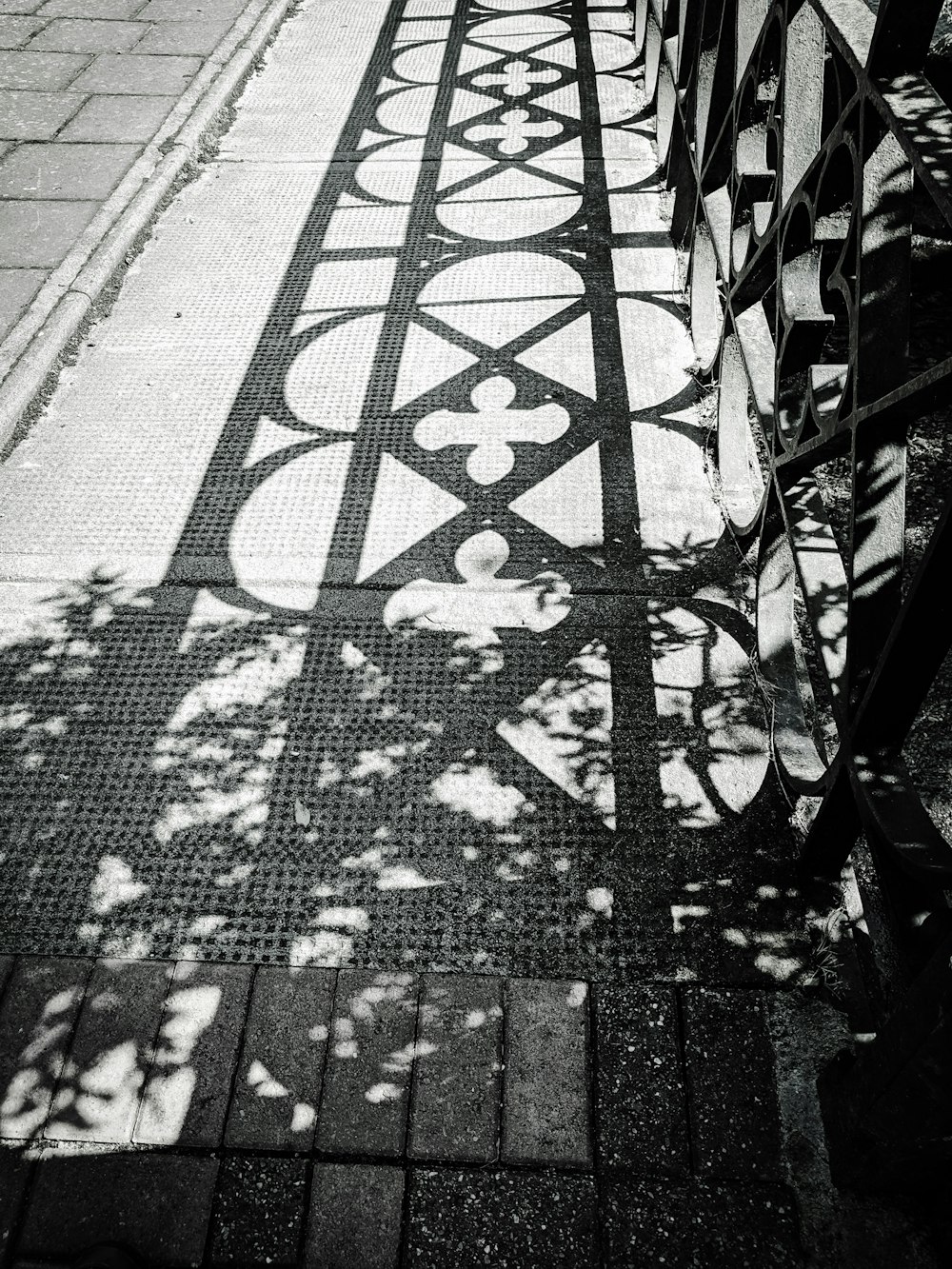 a black and white photo of a bench on a sidewalk